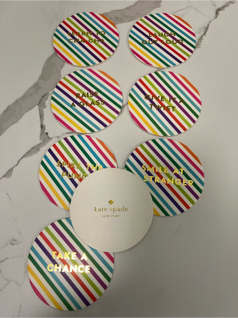 Brand new. Kate Spade Coaster set. Brightly striped with festive & fun sayings.